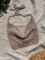 Crochet halter top white sand appoggiato su telo bianco con luce naturale. handmade in Italy by mysunflowerlab